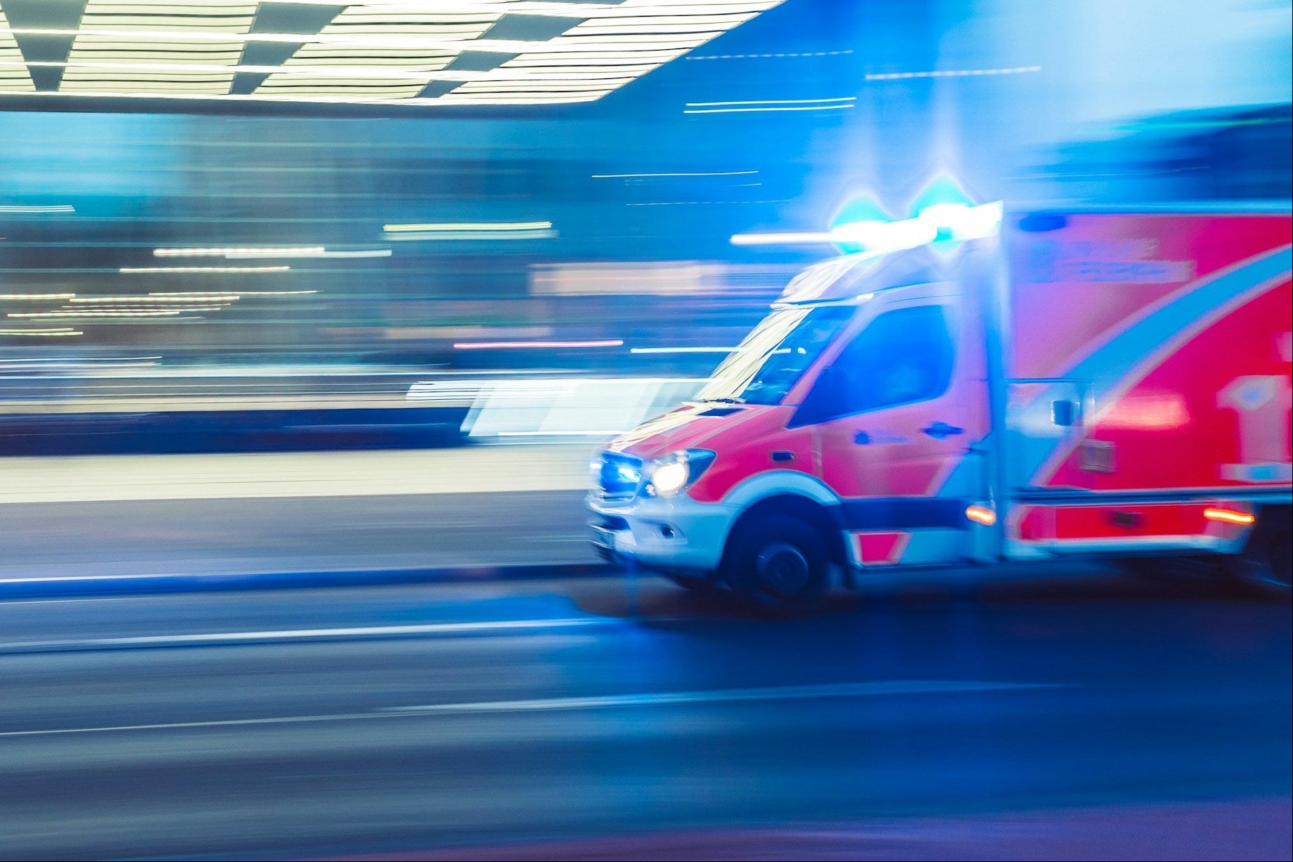Ambulance with flashing lights on a city street at night